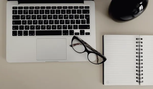 Carnet ouvert et ordinateur sur un bureau pour préparer une relecture